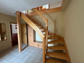 A wooden staircase leading to a lofted area with a window. - Ferienwohnung Kastellaun Zentrum (Kastellaun)