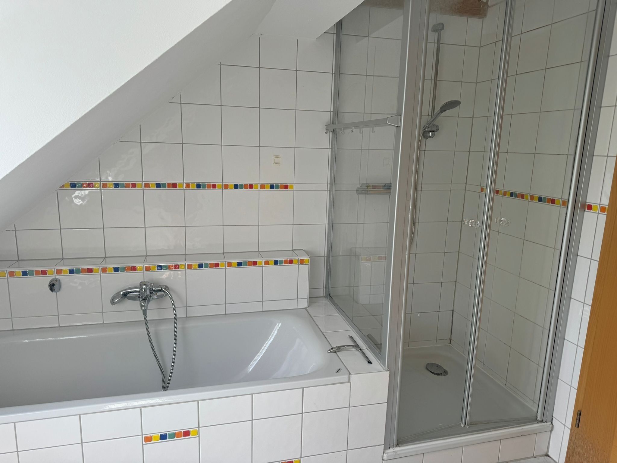 Une salle de bain avec une baignoire, une douche et des murs carrelés.