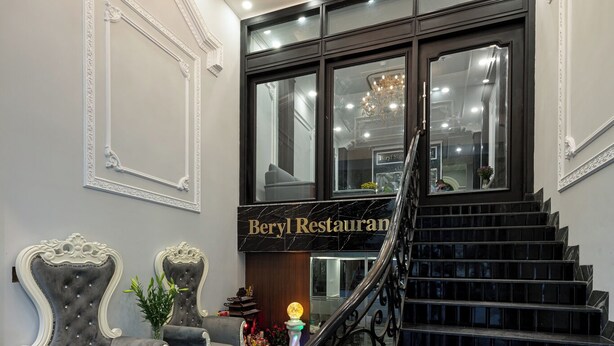 Eine prächtige Treppe führt zu einem Restaurant mit Marmorböden und aufwendigen Stühlen.