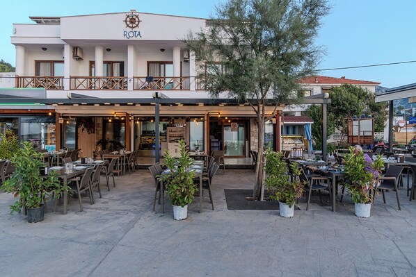 Un restaurant doté d’une terrasse, d’un patio couvert et d’une enseigne indiquant « ROTA ».