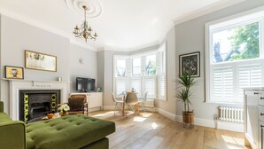 Amplia sala de estar con chimenea, televisor y comedor con mesa y sillas.