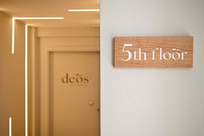 A wooden sign indicating the 5th floor of a building.
