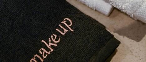 Two towels with embroidered text, one reading "deos" and the other "make up".