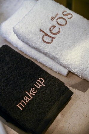 Two towels with embroidered text, one reading "deos" and the other "make up".