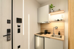 A modern kitchen with built-in appliances, a sink, and a countertop. - Deos living experience 1 (Athina)