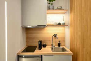 Una cocina moderna con lavavajillas, cafetera, fregadero y horno empotrado.