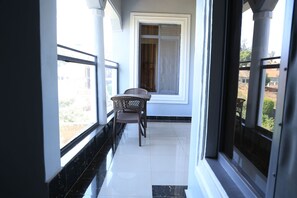 Step into a serene corridor leading to a balcony with a view of the surrounding neighborhood.