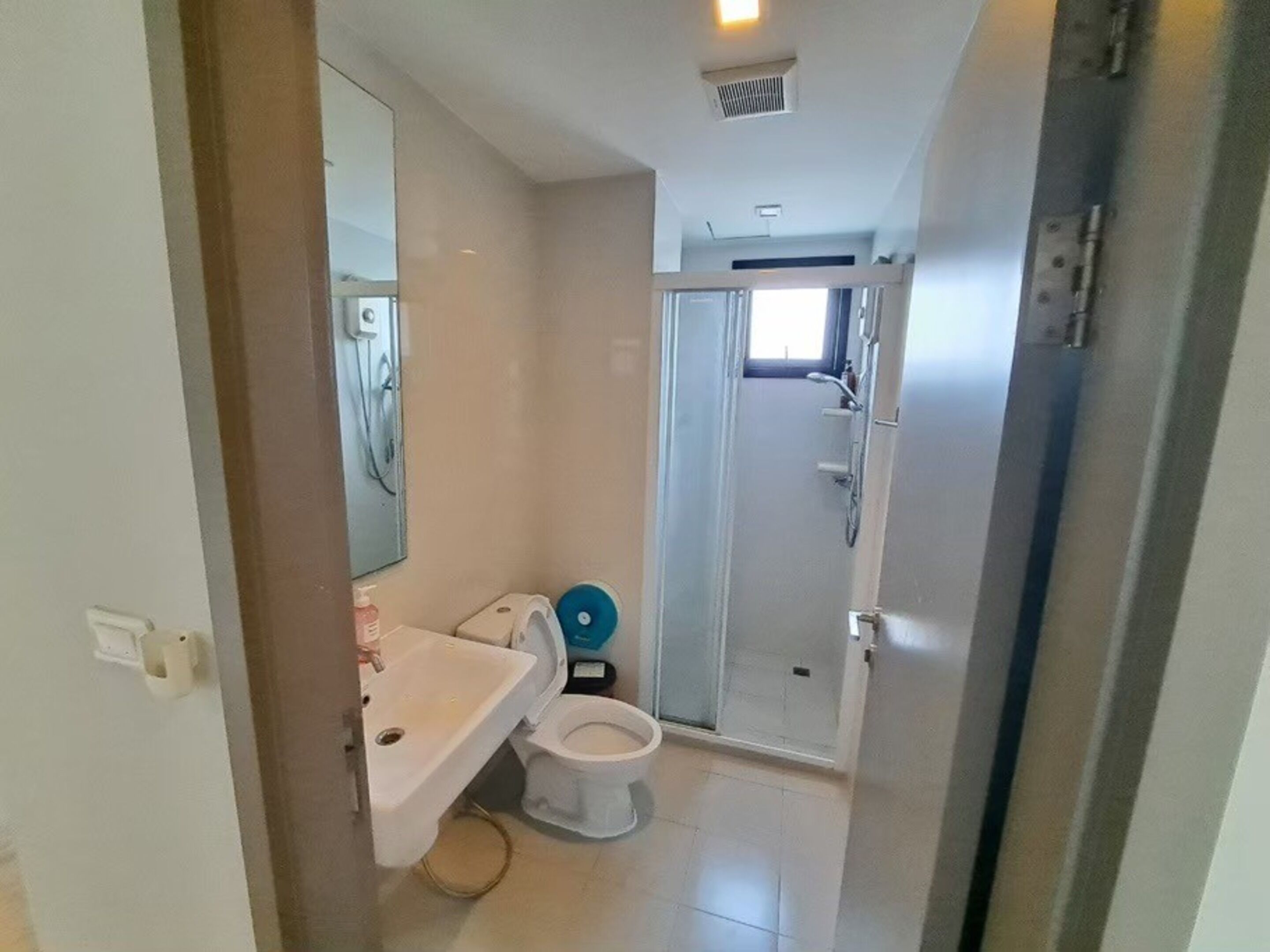 Une petite salle de bain comprenant des toilettes, un lavabo et une douche.