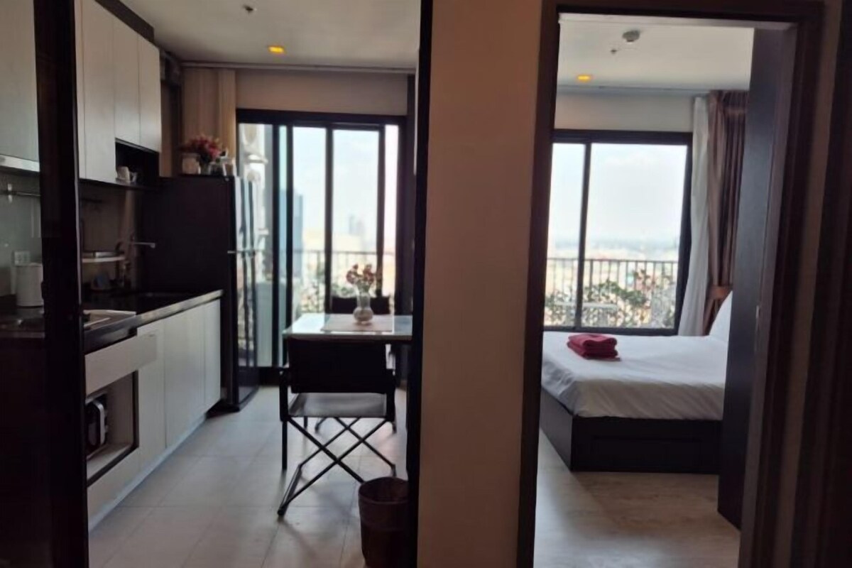 A modern apartment with a balcony, a kitchenette, and a dining area.