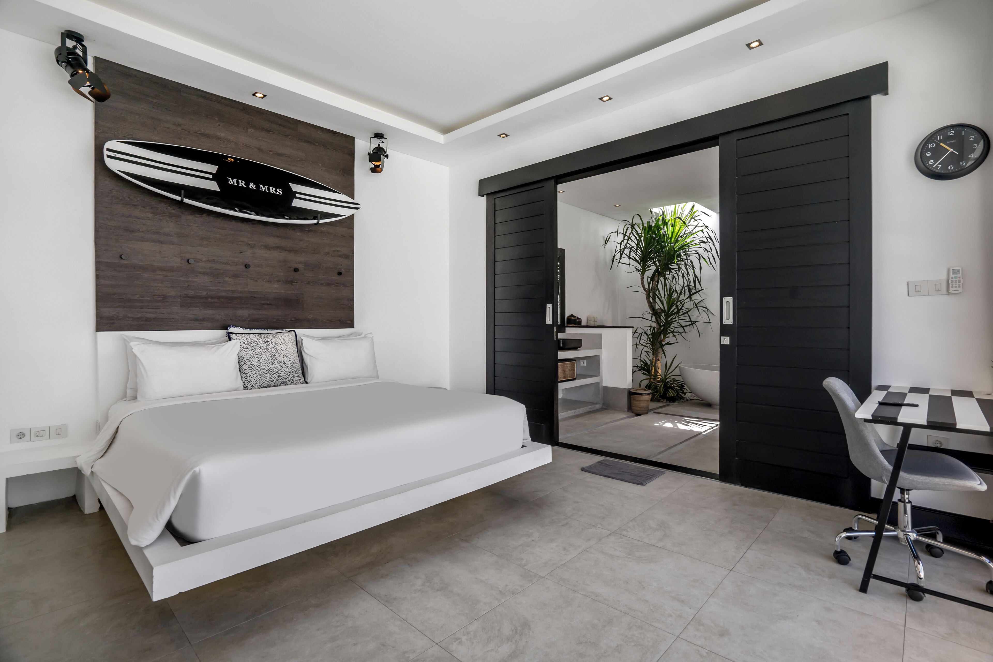 A modern bedroom with a bed, a desk, and a chair.