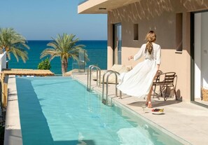 A poolside area with a view of the sea, a woman in a white dress, and outdoor furniture. - Golden Bee Lifestyle (Hersonissos)