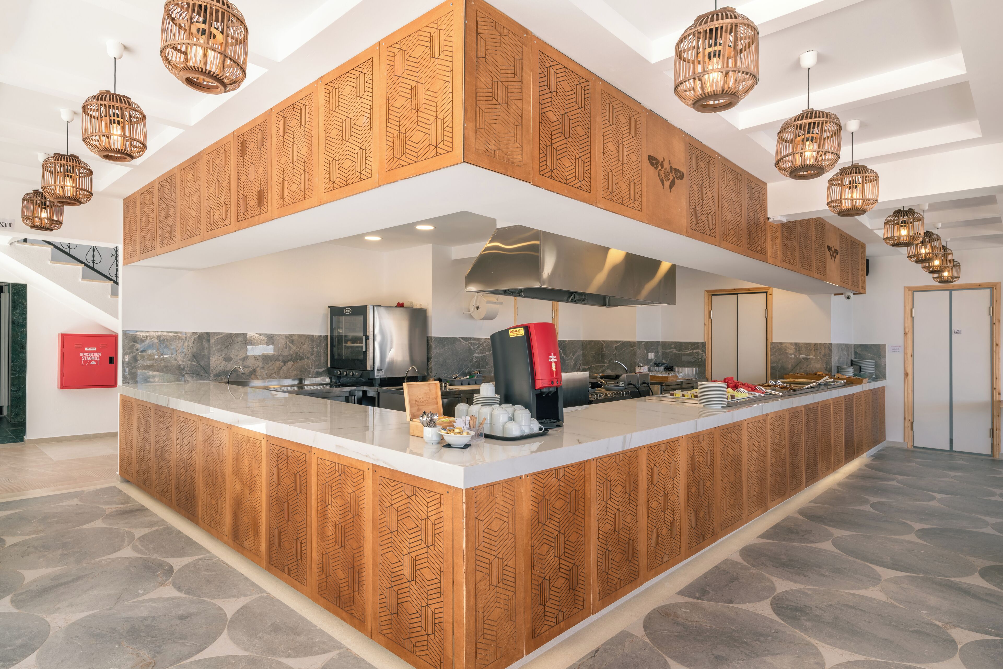 Cozinha moderna com ilha central, armários de madeira embutidos e iluminação pendente.