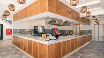 Cozinha moderna com ilha central, armários de madeira embutidos e iluminação pendente.