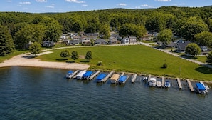An aerial view of a lakeside community with houses, a dock, and boats. - Honeoye Lake | Hot Tub | Kayak | Fire Pit (Honeoye)