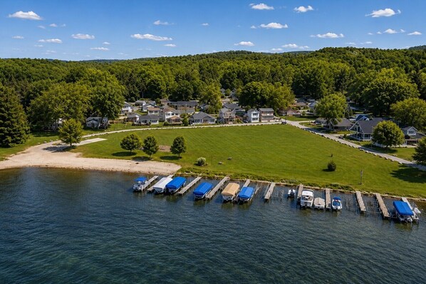 An aerial view of a lakeside community with houses, a dock, and boats. - Honeoye Lake | Hot Tub | Kayak | Fire Pit (Honeoye)