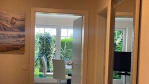 Un intérieur moderne comprenant un coin repas, une grande fenêtre et une vue sur l’extérieur.