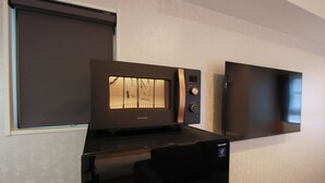 Eine moderne Küche mit integriertem Mikrowellenherd und Backofen, einer schwarzen Arbeitsplatte und einem Fenster mit Blick.