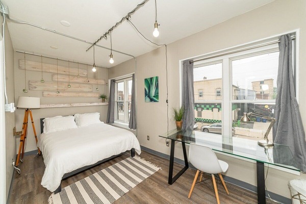 Classy spa/industrial decor bedroom with queen bed.