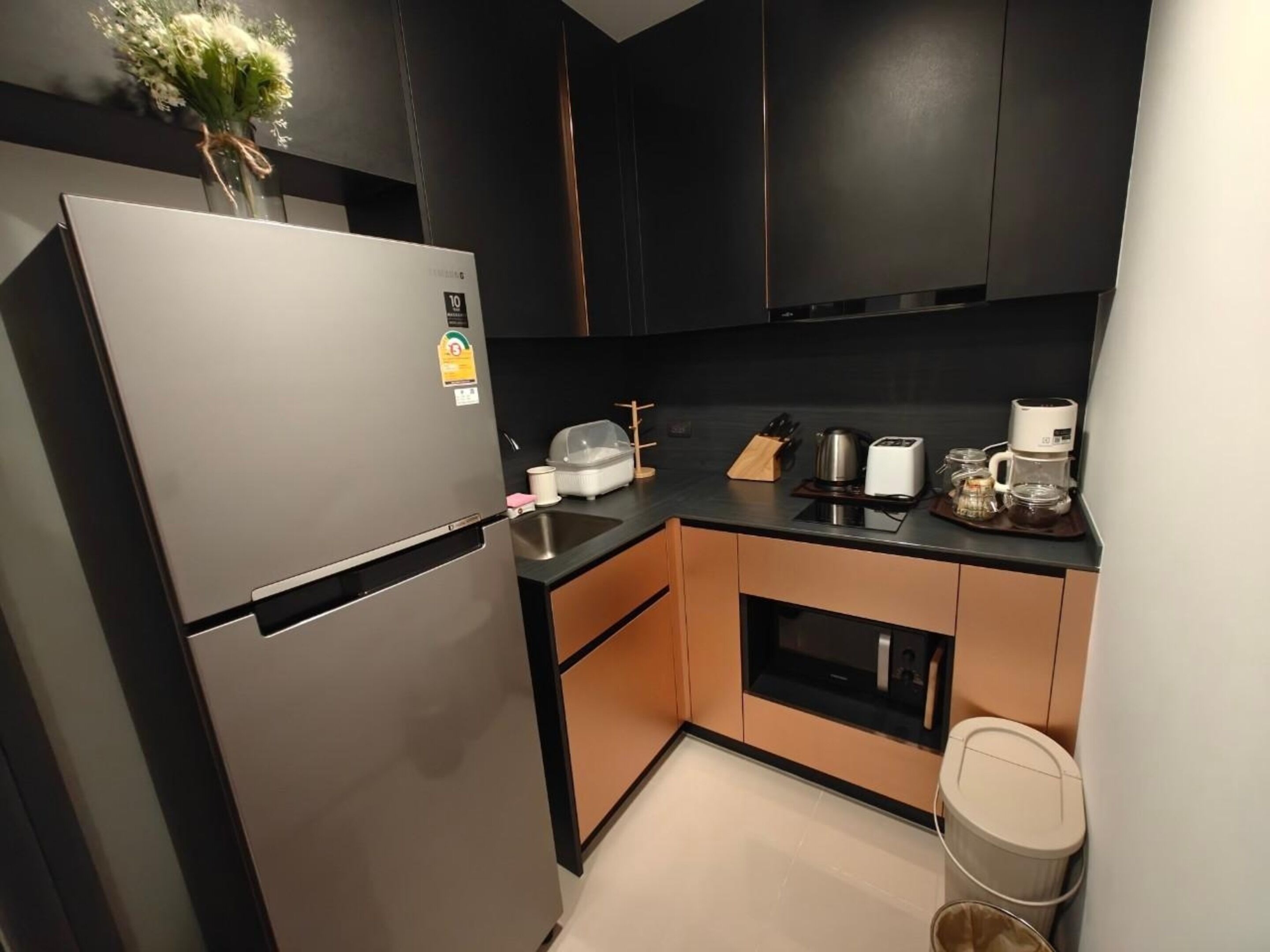 A modern kitchen with a stainless steel refrigerator, a coffee maker, and a toaster on the counter.