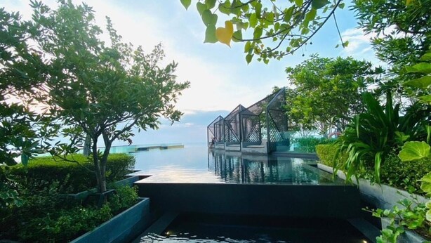 An infinity pool with a view of a bridge and overwater structures. - Edge Central Pattaya by Mickey (Pattaya)