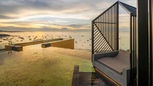 A modern outdoor deck with a view of boats on the water. - Edge Central Pattaya by Mickey (Pattaya)