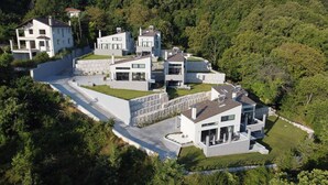 Un moderno complejo residencial con varias casas de dos plantas, con techos planos, ventanas amplias y paredes de piedra.