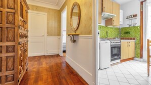 Uma cozinha com armários de madeira, fogão e painel de parede verde.