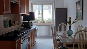Une cuisine moderne avec des meubles en bois, une cuisinière et un coin repas comprenant une table et des chaises.