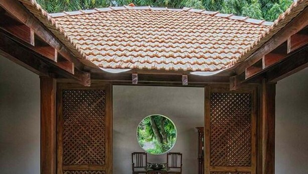 Une pièce de style japonais traditionnel, avec un sol recouvert de tatamis, une table basse en tatami, une table ronde et un petit bassin orné de nénuphars.