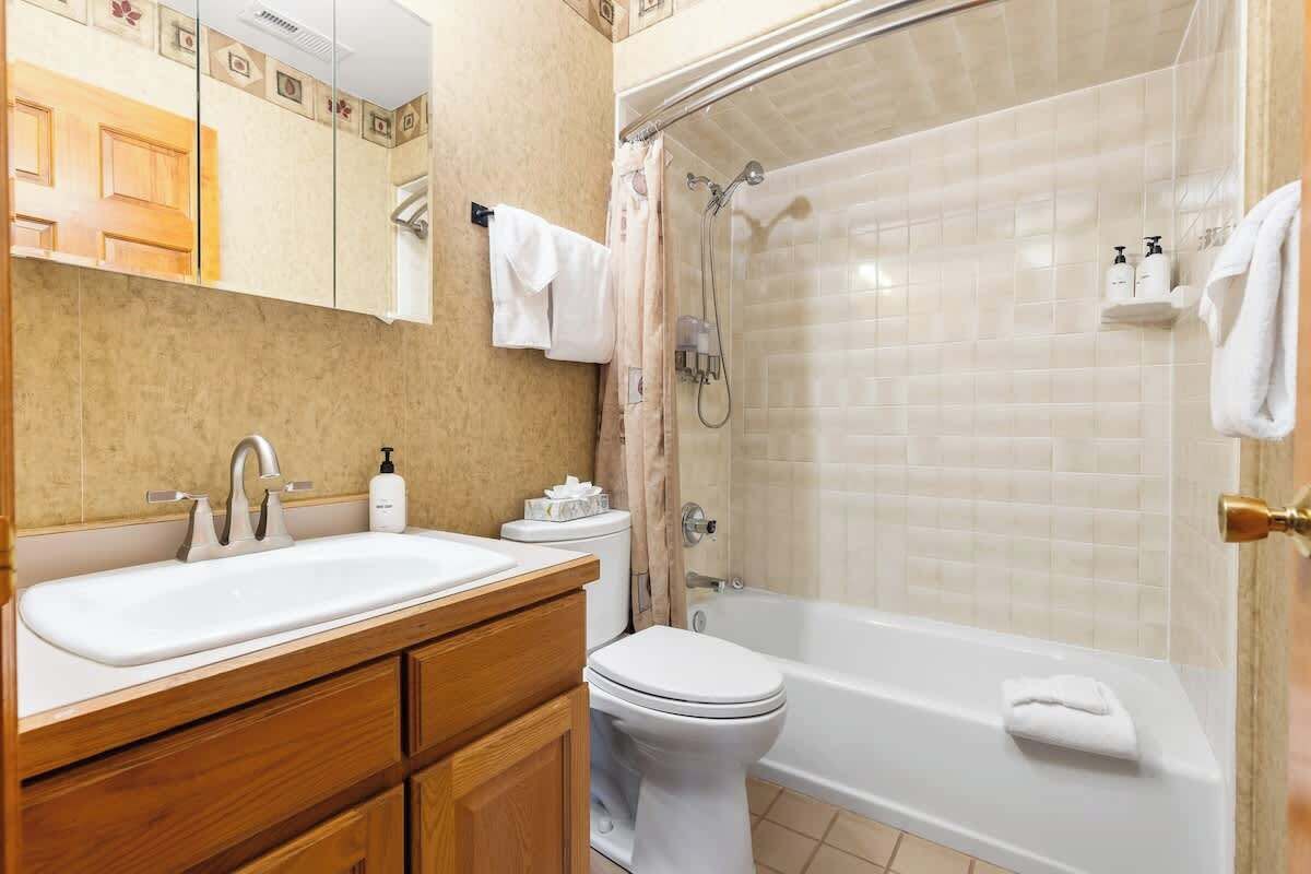 Un baño con lavamanos, inodoro y bañera.