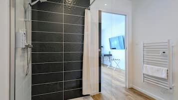 Deluxe eenpersoonskamer | Badkamer | Een douche, een haardroger, handdoeken, toiletpapier