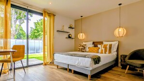 Une chambre à coucher avec un lit, une chaise, une table et une vue sur l’extérieur.
