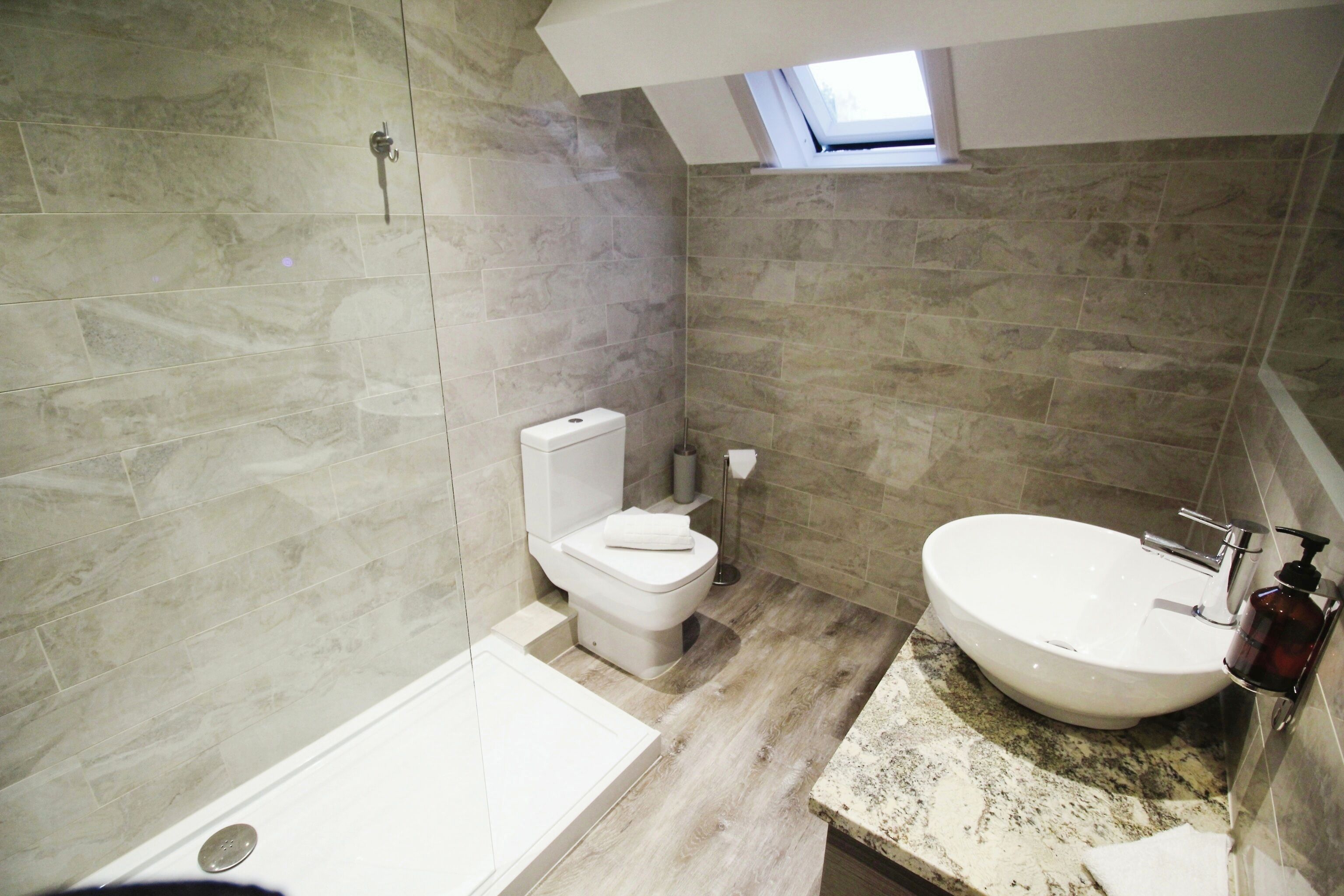 Een moderne badkamer met een badkuip, toilet en wastafel.