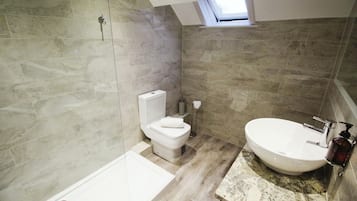 Een moderne badkamer met een badkuip, toilet en wastafel.