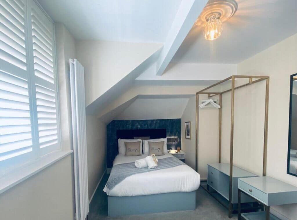 Ein Schlafzimmer mit einem Bett, Nachttischen, einem Kleiderschrank und einer Deckenleuchte.