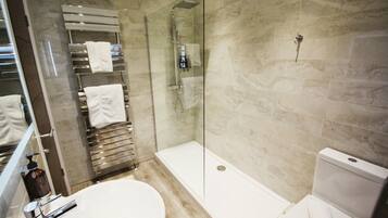 A modern bathroom with a glass-enclosed shower, a toilet, and a sink.