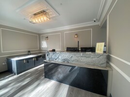A modern kitchen with a marble countertop, built-in appliances, and pendant lighting.