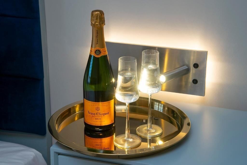 A bottle of Veuve Clicquot Brut champagne on a tray with two glasses.