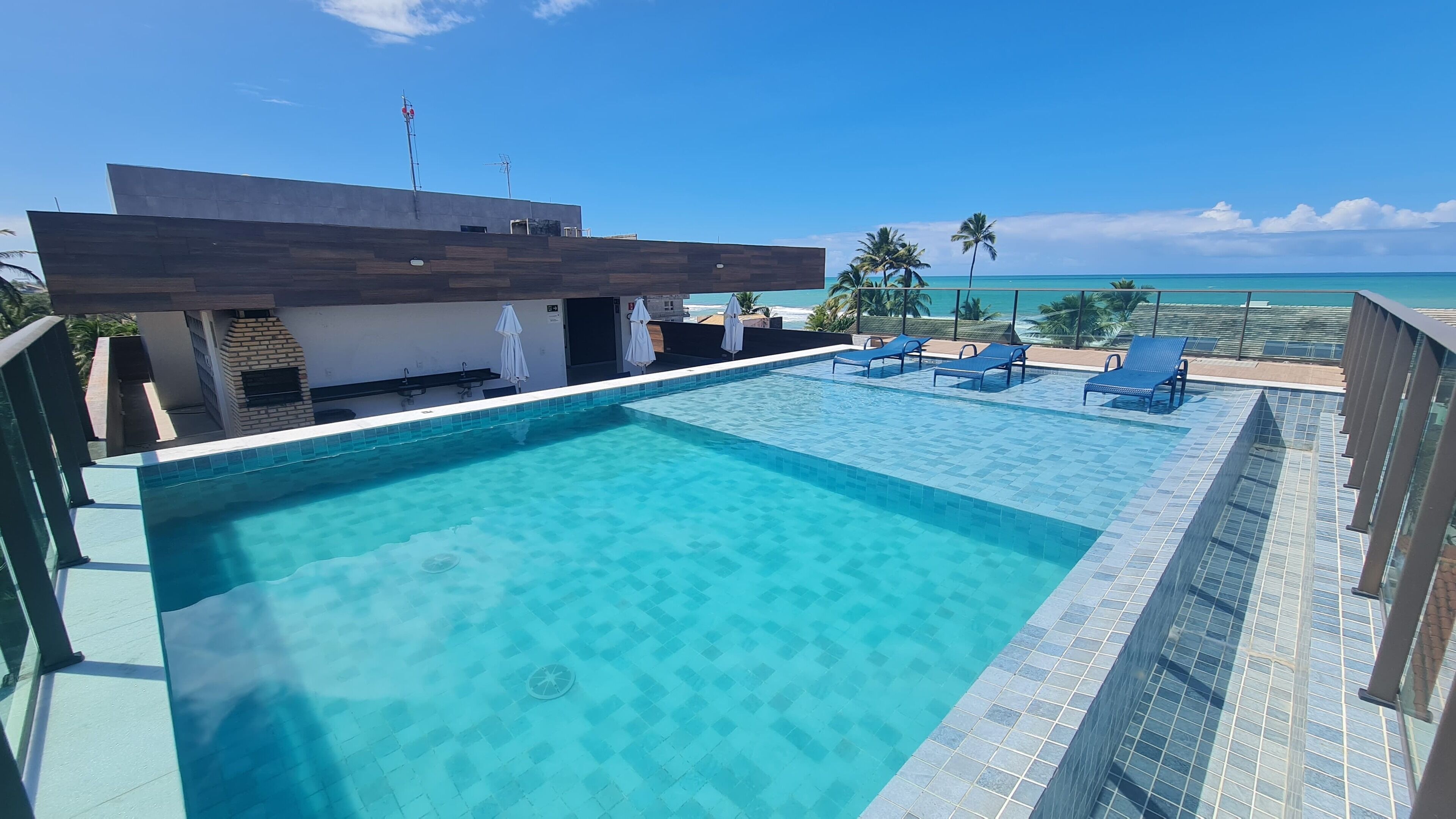 Una piscina al aire libre, sombrillas, tumbonas