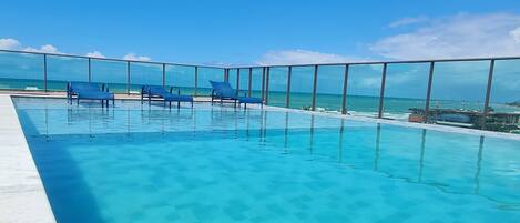 Piscine extérieure, parasols de plage, chaises longues