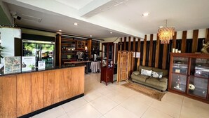 A reception area with a wooden counter, a sofa, a chandelier, and a display cabinet. - Rajpracha Pakchong (Pak Chong)