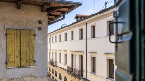 A building with a balcony, a window with a shutter, and a door. - AureliaHome@Pescheria (Treviso)