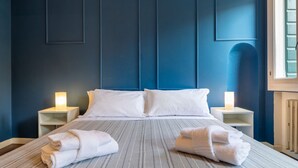 A hotel room with a large bed, two bedside tables with lamps, and towels on the bed. - AureliaHome@Pescheria (Treviso)