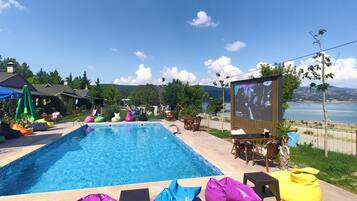 Relax by the serene pool surrounded by lush greenery and ocean views.
