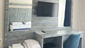 A hotel room with a bed, a desk with a flat-screen TV, a chair, and a mirror. - Celik Hanim Termal Otel & Spa (Ulukisla)