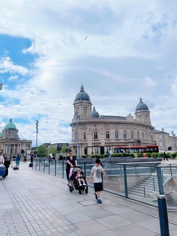 A pedestrian walkway with a historic building featuring domed architecture in the background.