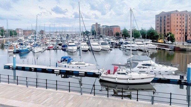 A marina with numerous boats docked, a waterfront promenade, and a multi-story building in the background. - HushHavenHull-SLEEP 4| Wifi+Netflix| SnookerTable (Kingston upon Hull)