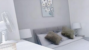 A modern hotel room with a bed, two bedside lamps, a wall-mounted fan, and a decorative wall piece. - HushHavenHull-SLEEP 4| Wifi+Netflix| SnookerTable (Kingston upon Hull)
