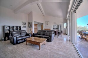 A spacious living room with a sofa, coffee table, and dining area. - FRGK Villa Le Petit Bois Panoramic View, Lush Ga (vallauris)