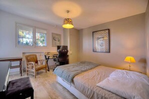 Une chambre à coucher avec un lit, un bureau, une chaise et un radiateur.